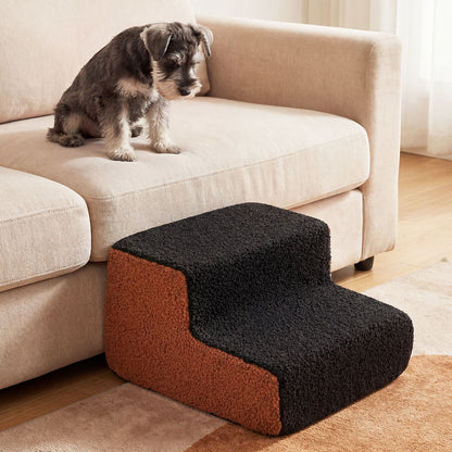 A medium-sized dog on a sofa looking down at the pet stairs