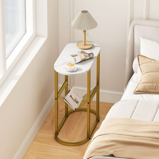 The side table placed in a bedroom next to a bed with a lamp and magazines on the mesh shelf