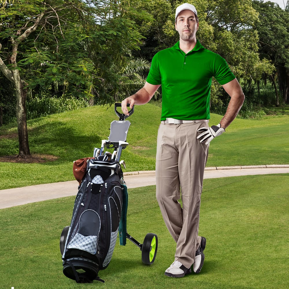 A man stands with the green golf cart beside him on a golf course