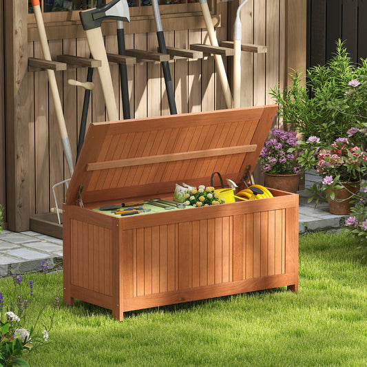 Wooden deck box with lid open, storing garden tools and a yellow watering can