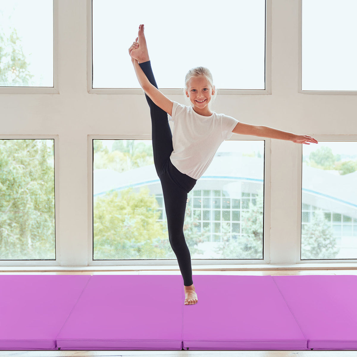 The purple floor mat providing a surface for a young girl doing a standing split