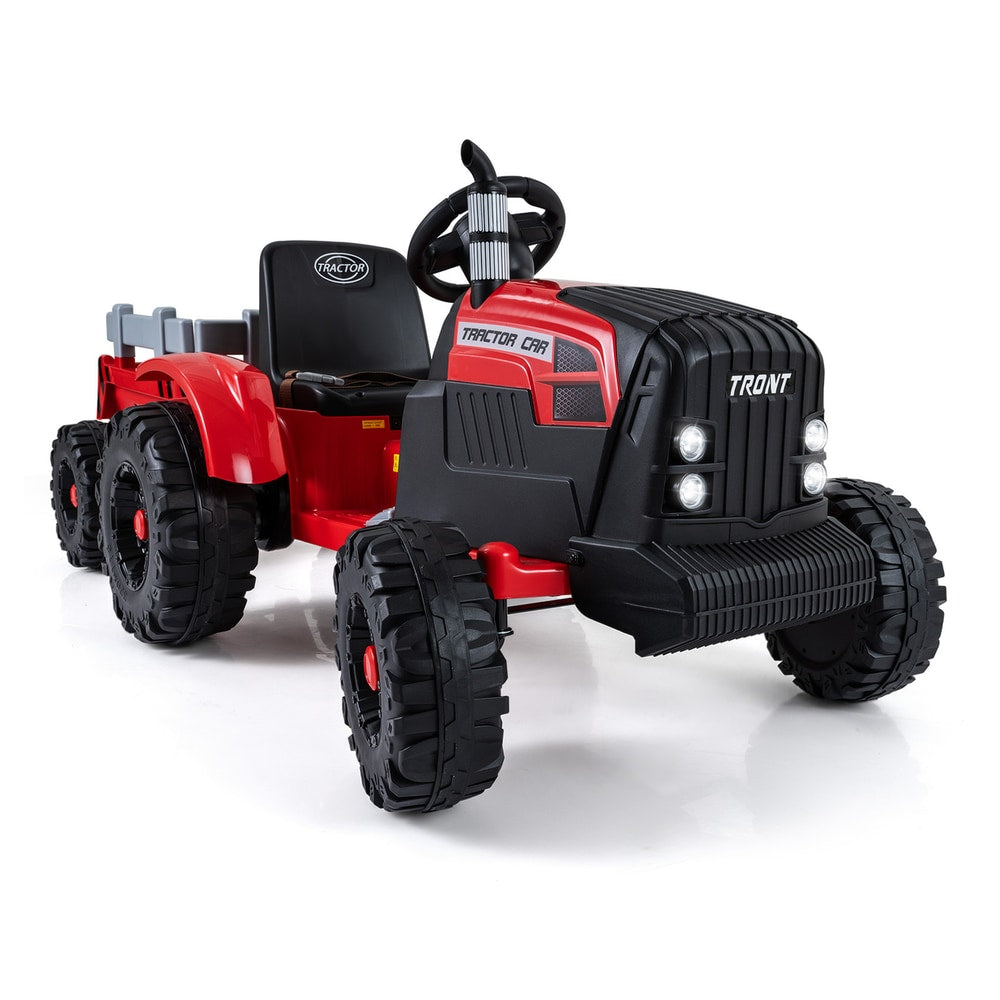 The red kids electric tractor with detachable trailer is shown from a low angle