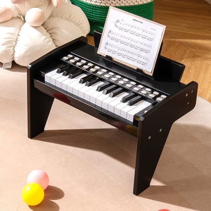 The black wooden toy piano with sheet music on the stand, surrounded by toys
