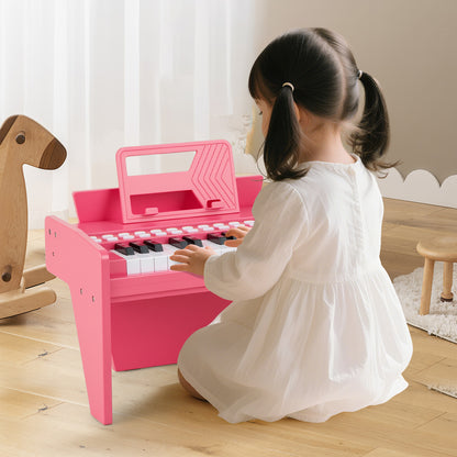 Young child playing the pink wooden toy piano