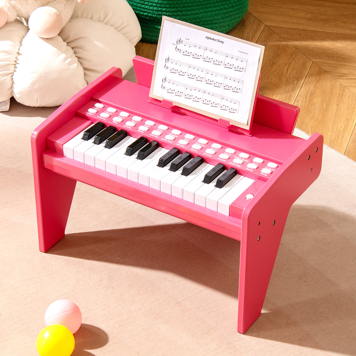 Pink wooden toy piano with sheet music on stand