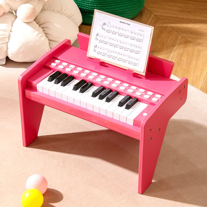 Pink wooden toy piano with sheet music on stand