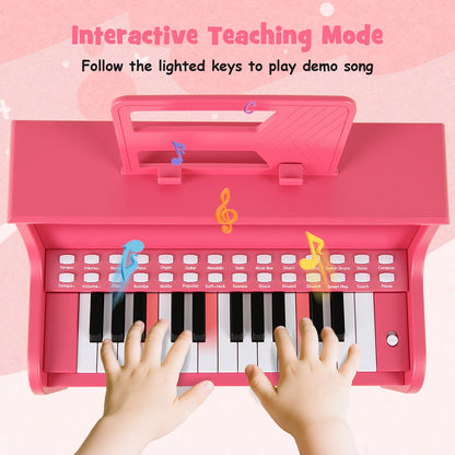 Close-up of a child's hands playing the pink kids piano keyboard with lighted keys