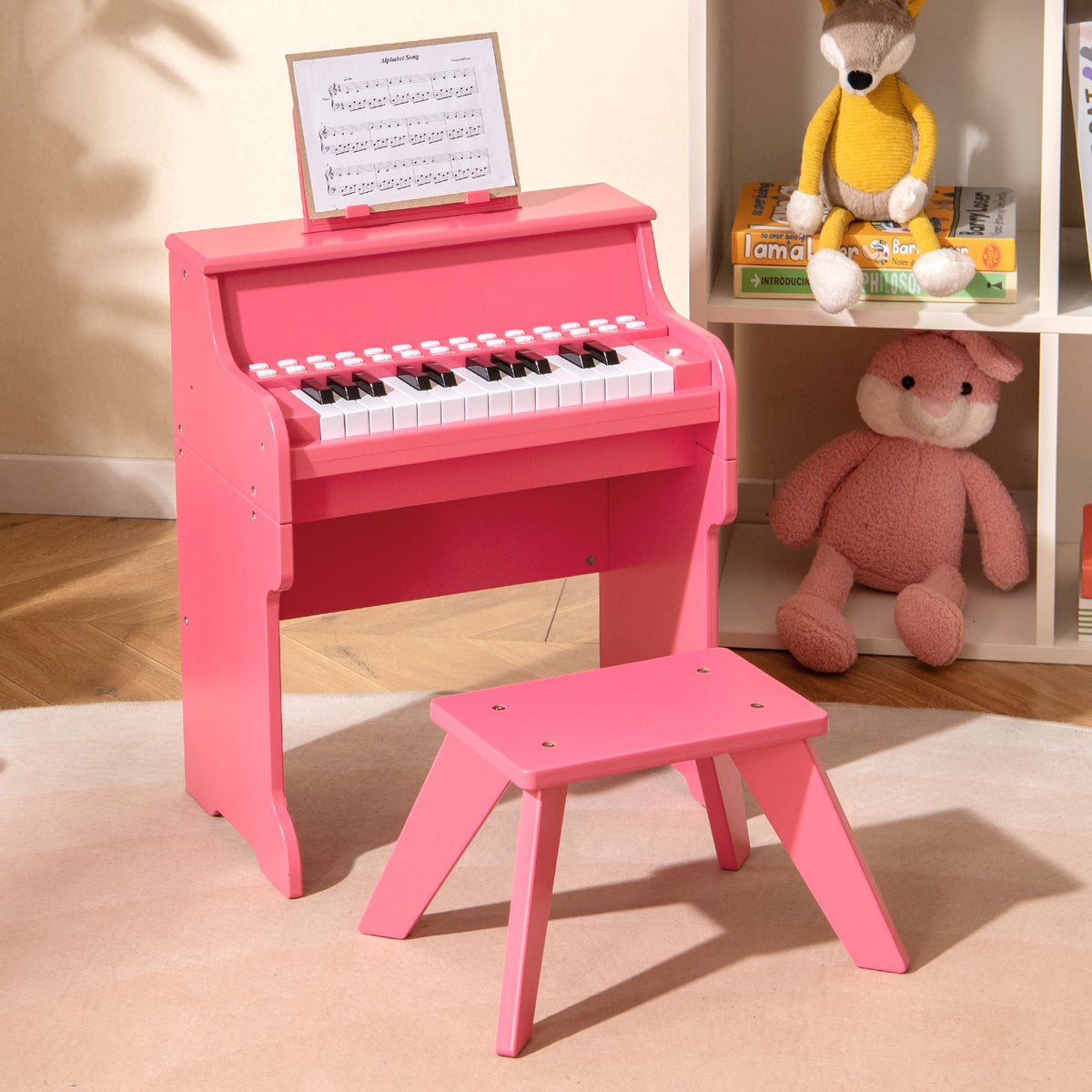 Pink kids piano keyboard with stool and sheet music on a shelf in a nursery
