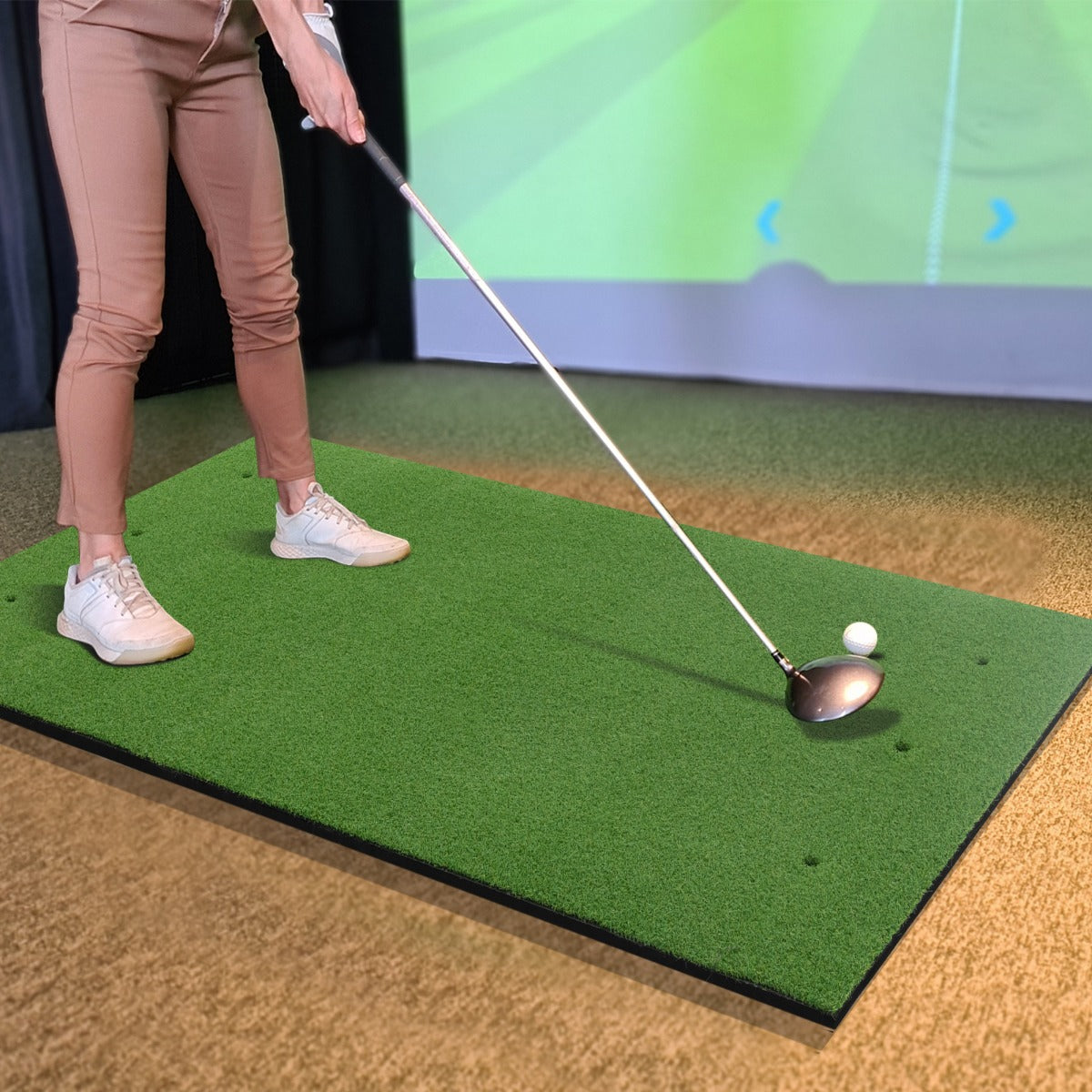 The golf hitting mat set up indoors with a person practicing their swing