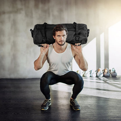 The training sandbag held on the shoulders of a man performing a squat in a gym