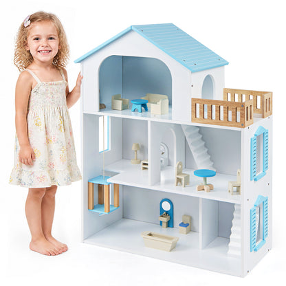 A young girl standing next to the wooden dollhouse playset