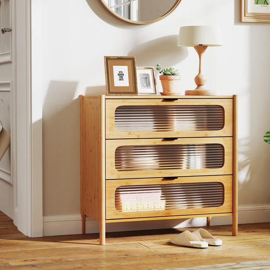 The chest of drawers in a hallway with shoes and a lamp nearby