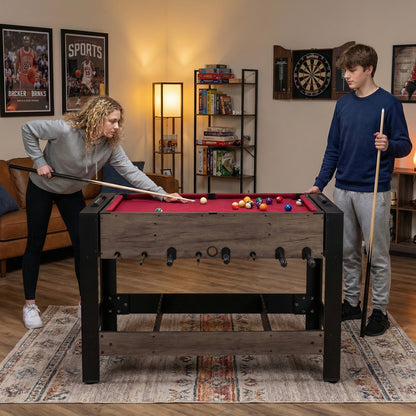 The game room table being used by two people playing pool in a furnished room