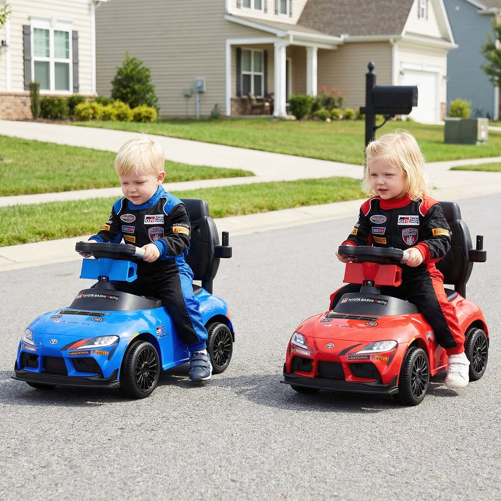 Two toddlers in racing outfits sitting in a blue and a red version of the push car