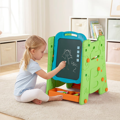 A young girl sitting on a rug drawing on the chalkboard side of the art easel