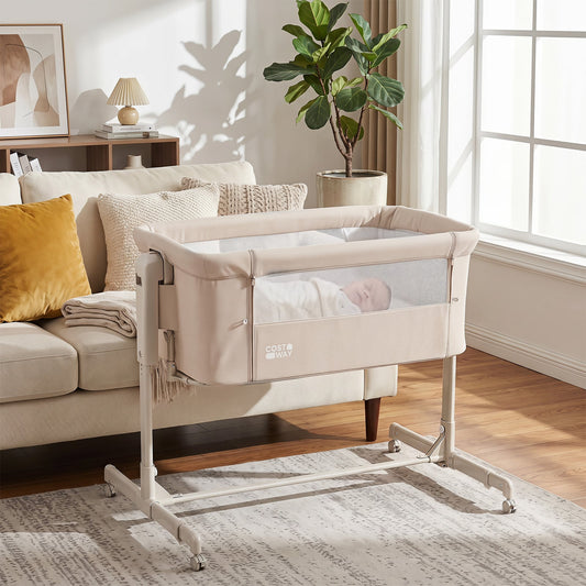 beige bedside sleeper with a baby inside, placed next to a sofa