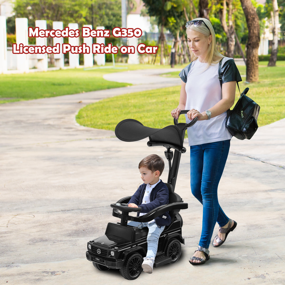 Woman pushing a baby in the black sliding walker with push handle outdoors