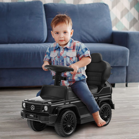 Toddler sitting in the black sliding walker with push handle, steering the wheel
