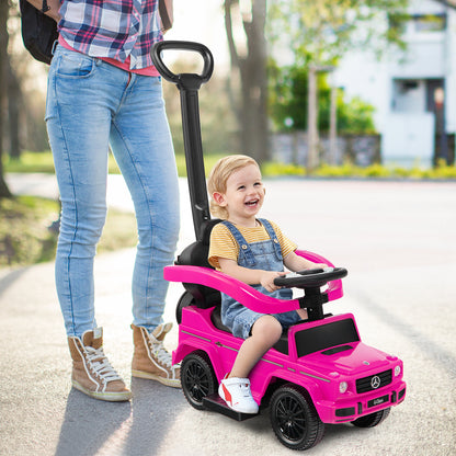 A smiling baby sits in the pink ride-on toy car, pushed by a woman