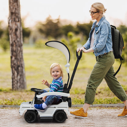 Woman pushing a toddler in the white baby walker car outdoors on a path