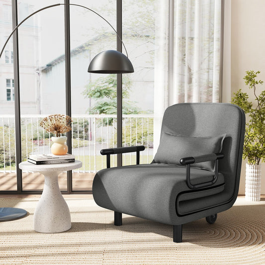 The grey convertible sofa bed in a living room setting next to a side table and a floor lamp