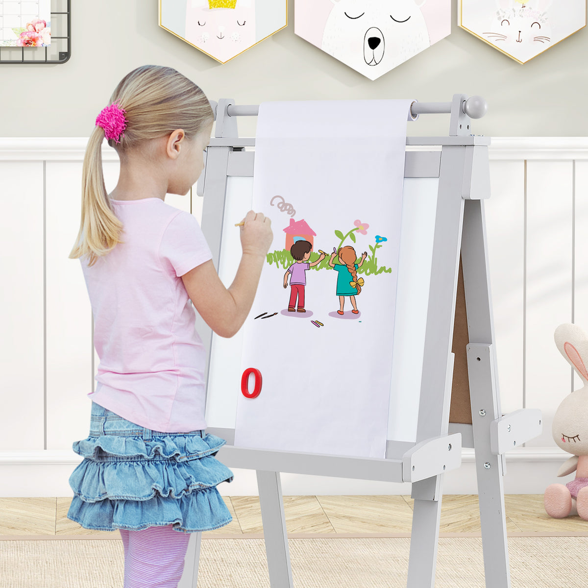 Girl drawing on the paper roll of the grey double-sided art easel