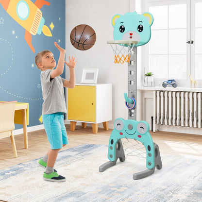 Boy playing basketball with the green toy sports hoop and stand set indoors