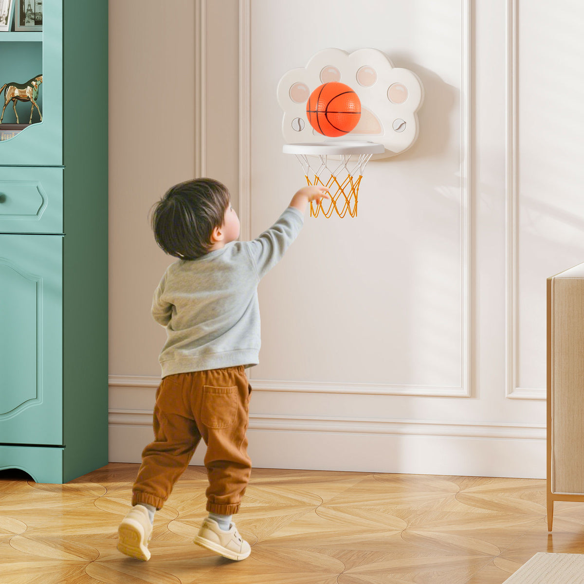 A young boy plays basketball on the toy sports center indoors