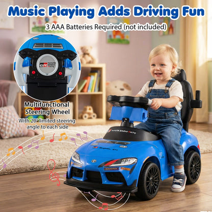 A toddler plays with the steering wheel of the blue push car with musical notes around