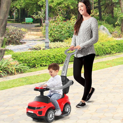 Mother pushing her child on a red ride on push car stroller in a park