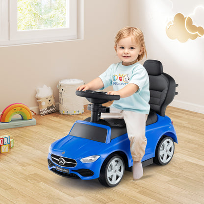 Toddler sitting in the navy blue push car with a steering wheel
