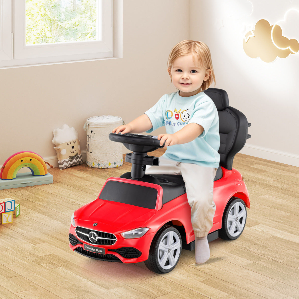 The push car being used by a young child sitting on the seat in a bright playroom