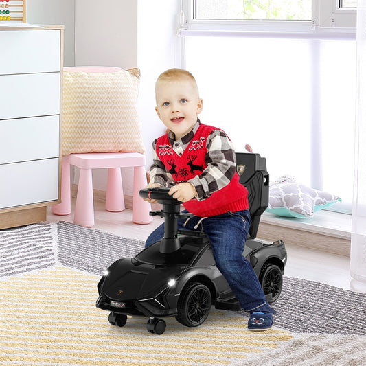 A smiling child sits in the black ride on push car indoors on a rug
