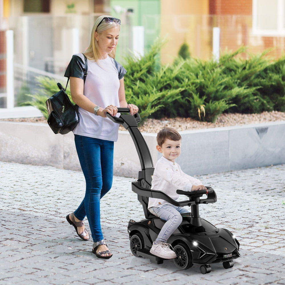 A woman pushes the black ride on push car with a child inside along a path