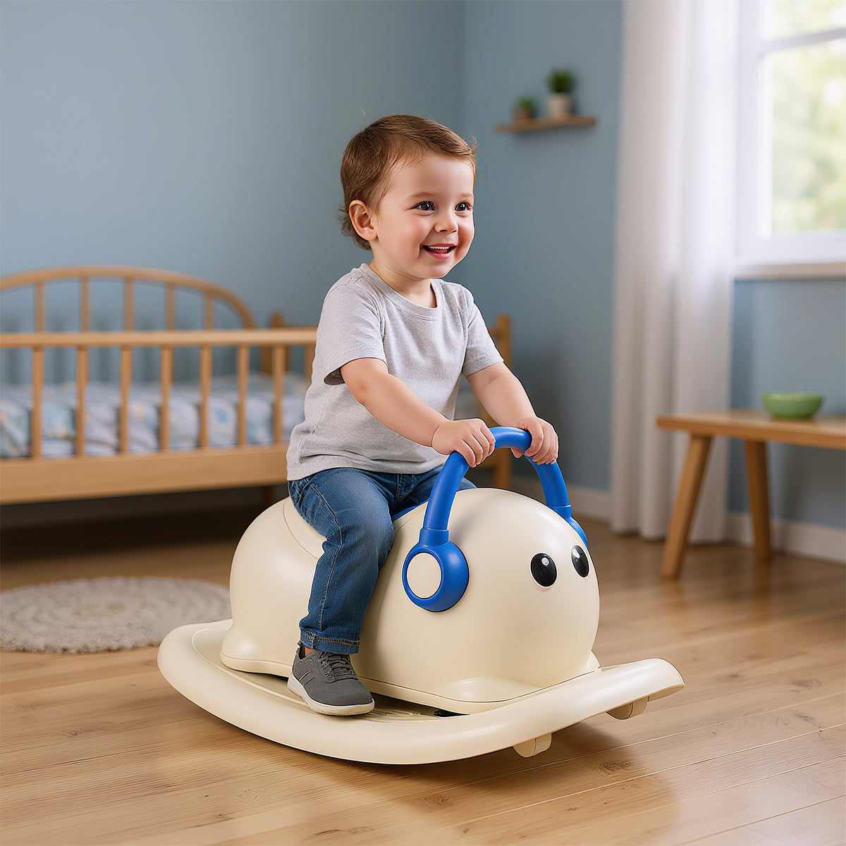 A happy toddler sits on the blue and cream rocking horse toy in a nursery room