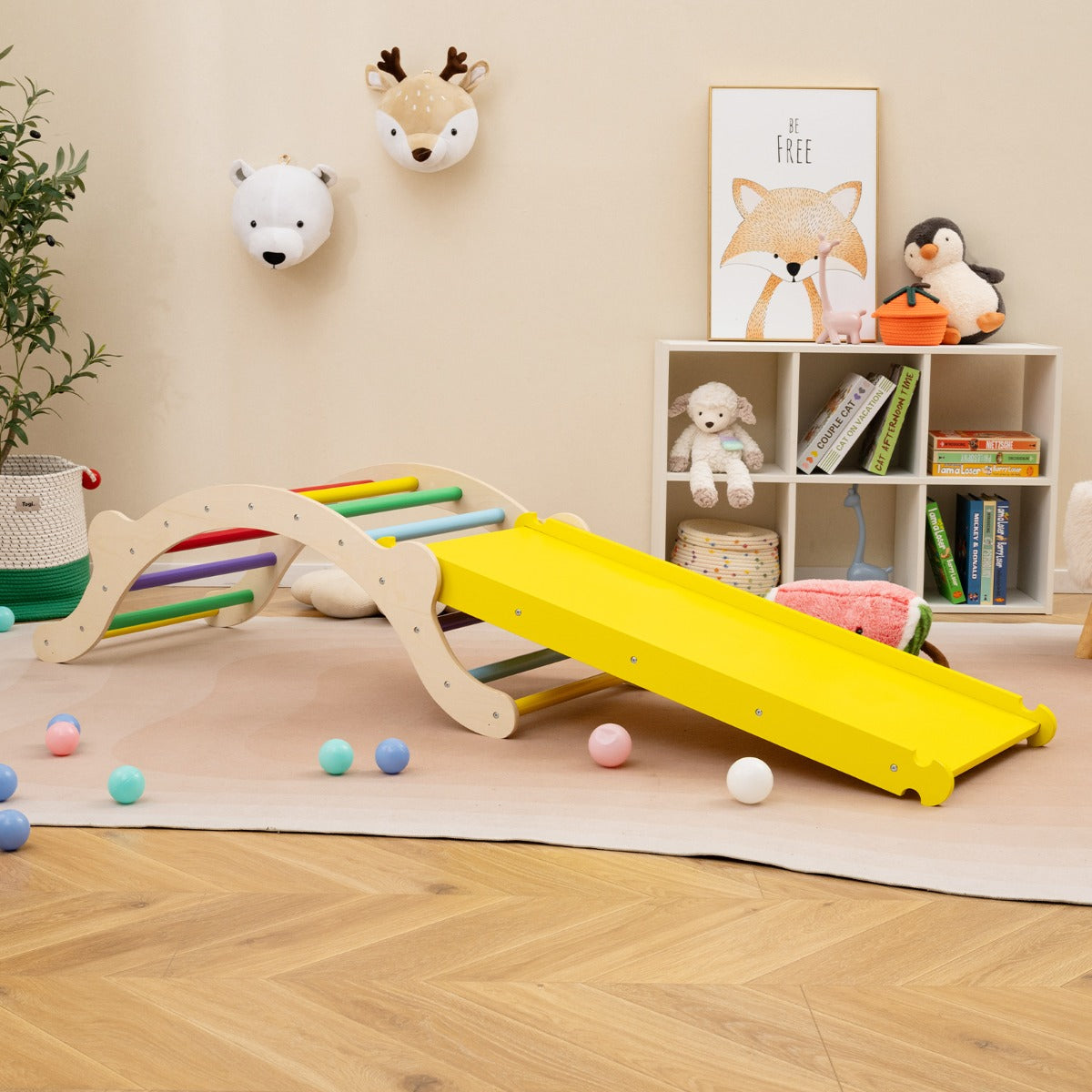 The wooden climber arch with ramp set up in a child's playroom with colourful balls scattered around