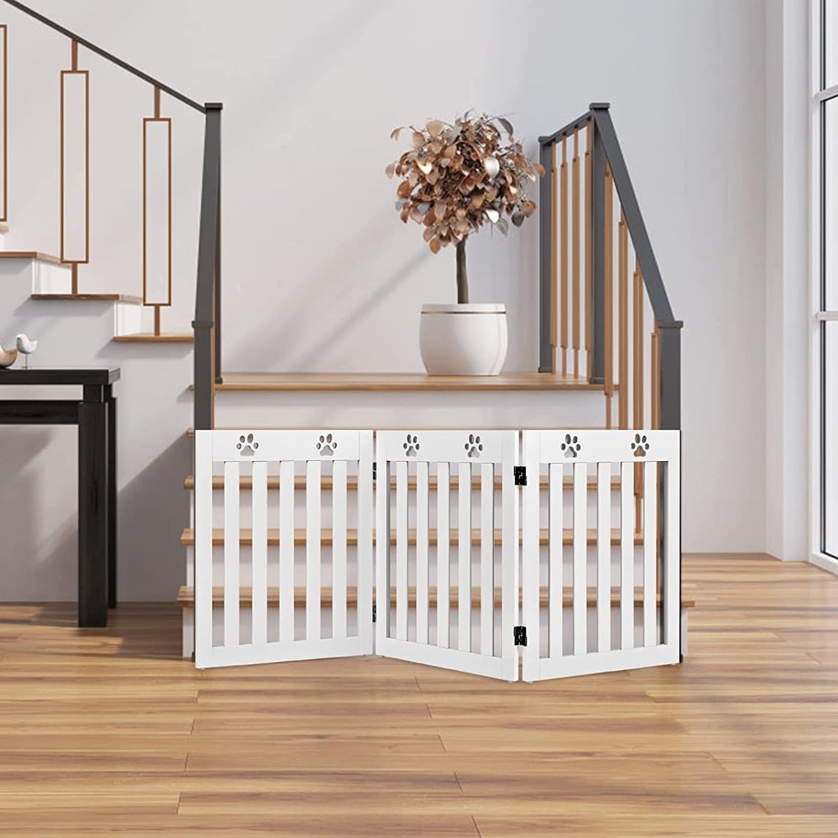 The white pet gate is set up at the bottom of a staircase in a modern home
