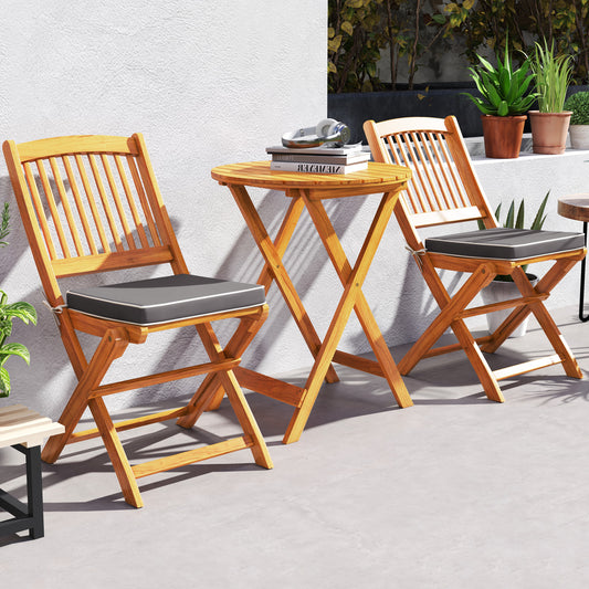 The patio furniture set placed on a grey balcony floor against a white wall with books on top