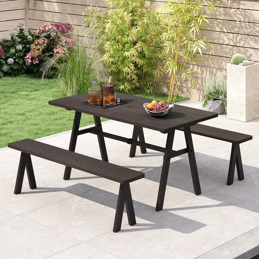 The picnic set placed on a patio in a garden with drinks and fruit on the table