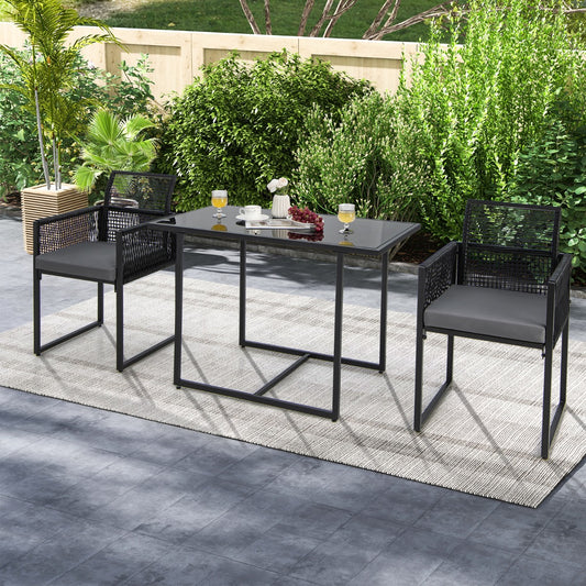 Black rattan dining set with two chairs and a table on a patio rug outdoors