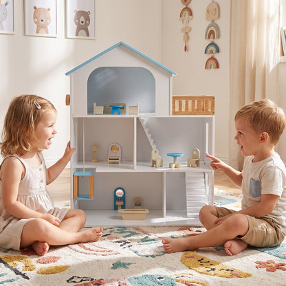 Two children playing with the wooden dollhouse playset on a rug
