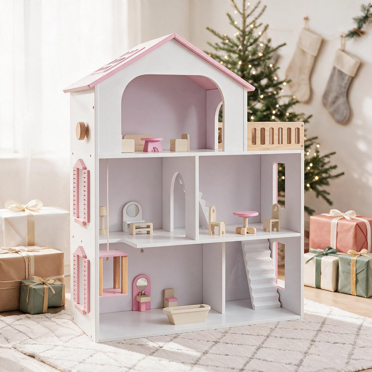 The pink wooden dollhouse set up in a festive room with wrapped gifts and a Christmas tree