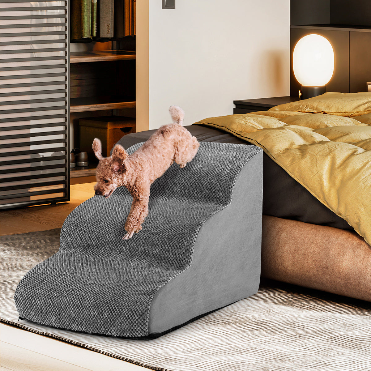 the dog ramp in grey, a small dog is walking down the steps next to a bed