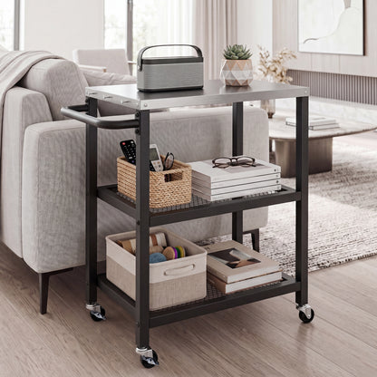 The rolling kitchen cart with a stainless steel top, holding books and a basket