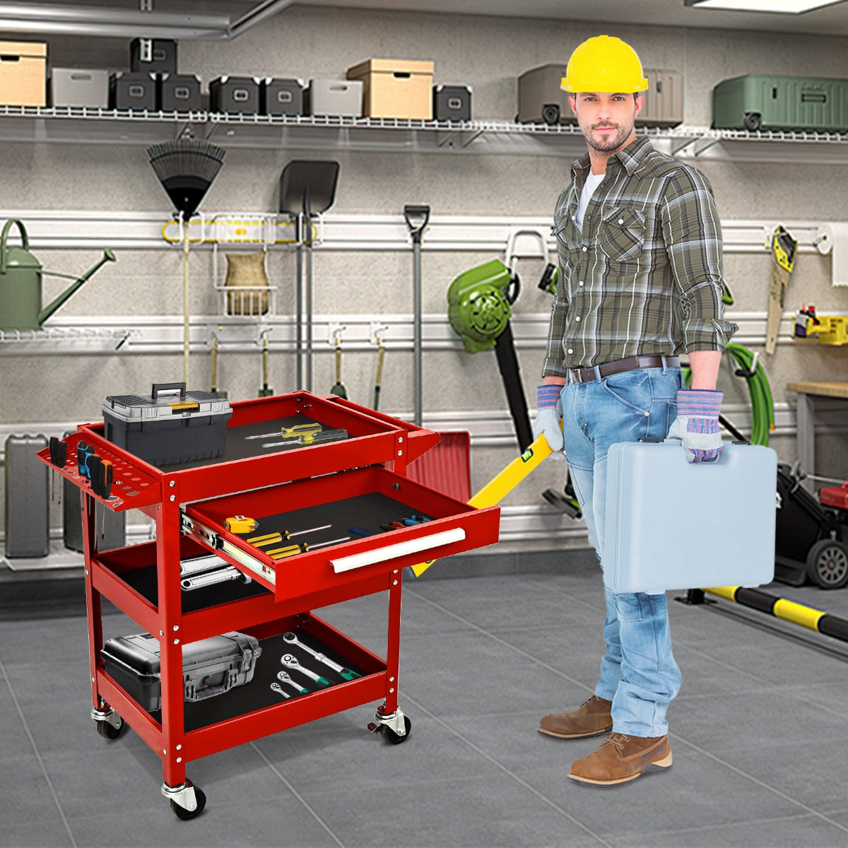 A man stands next to the red tool trolley with its drawer open, holding a toolbox