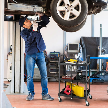 The three-tier folding tool trolley is used by a mechanic under a car