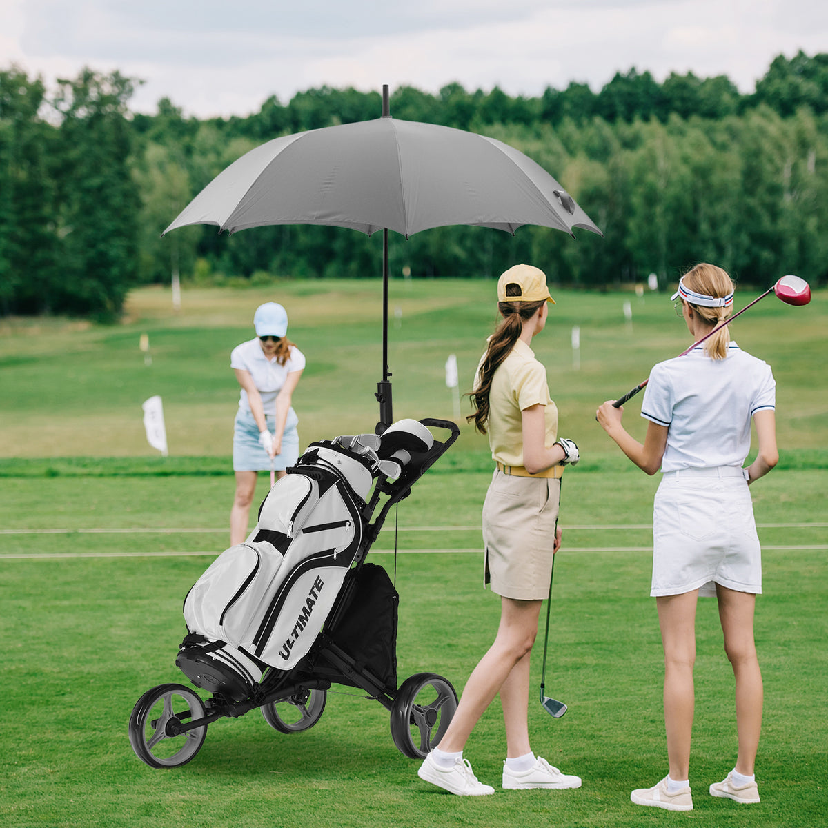 Two golfers with a golf bag on the three wheel golf trolley on a course