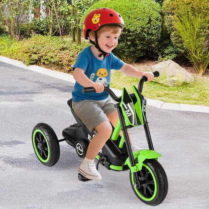 A young boy riding the toddler bike on a paved path in a garden setting