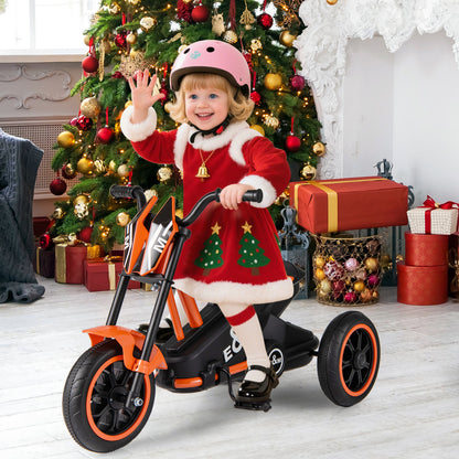 A child in a Santa outfit rides the orange three-wheel bike indoors with a Christmas tree in the background