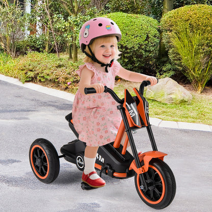 A happy toddler wearing a pink helmet rides the orange three-wheel bike outdoors on a paved path